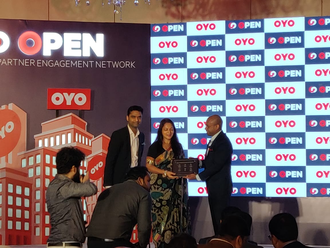 Ex.11 — partner recognition award presentation on stage at OYO OPEN